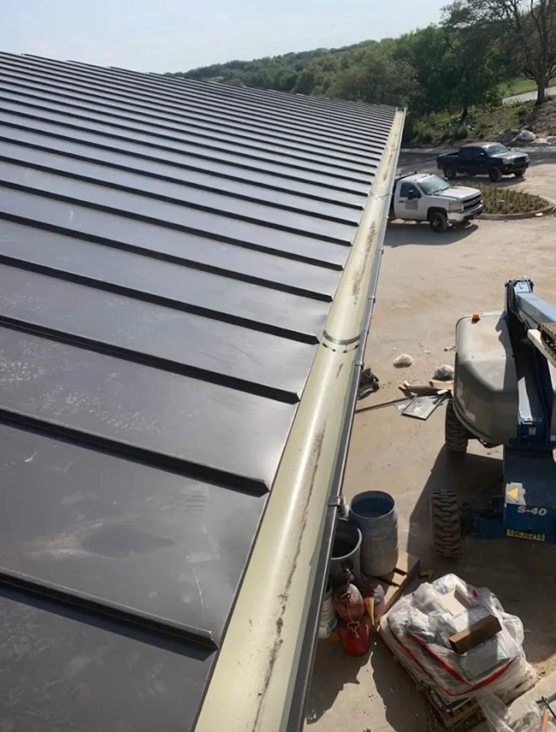 Standing seam panel and gutter detail on a metal roofing jobsite in Davenport
